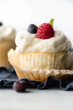 angel food cupcakes topped with whipped cream and berries