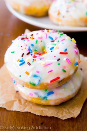 stack of 2 baked funfetti donuts topped with vanilla glaze and sprinkles
