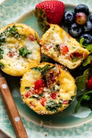 spinach and feta egg muffins on blue plate with berries in background.