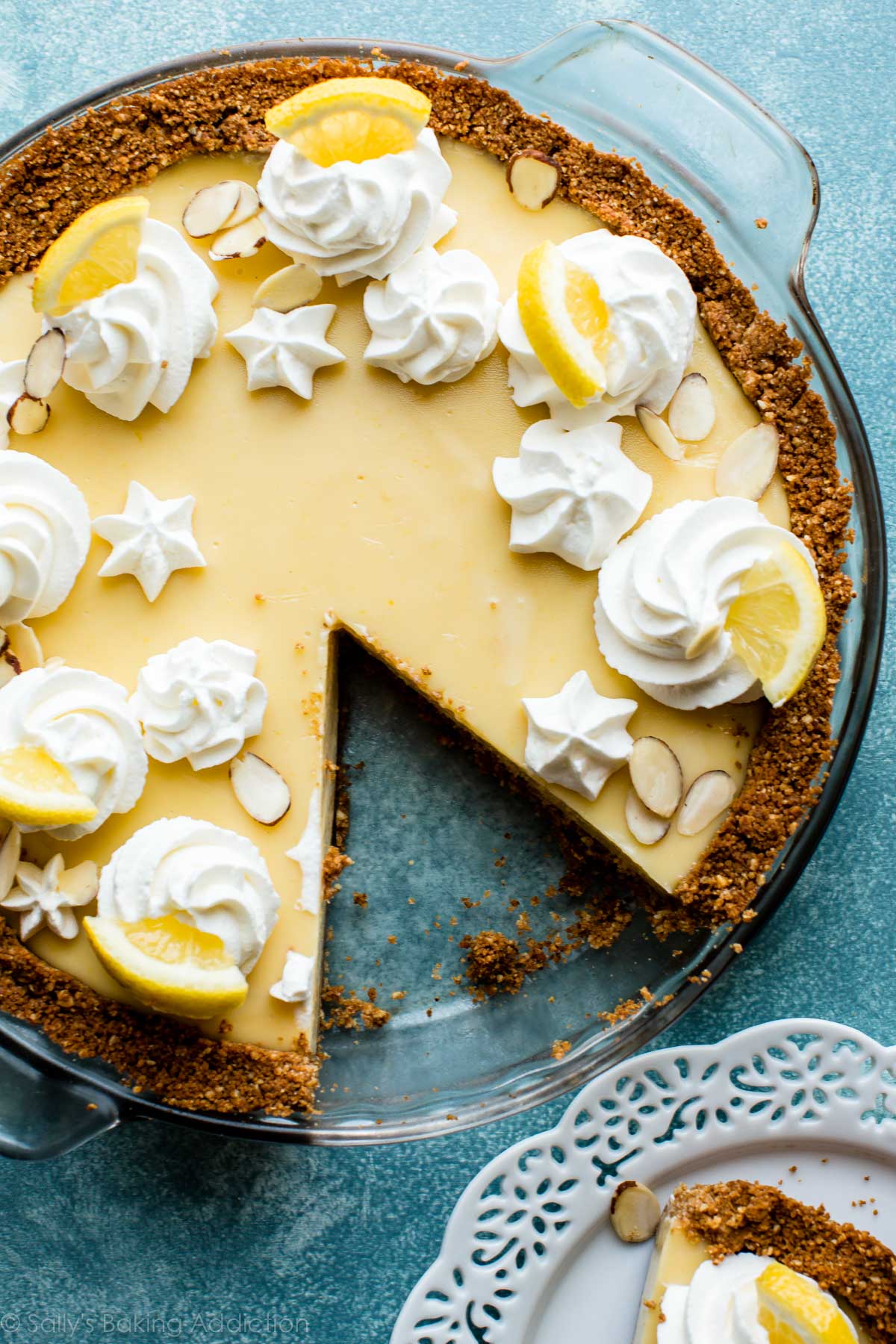 overhead image of lemon pie with whipped cream piping and lemon slices