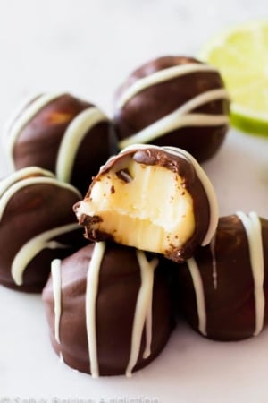 dark chocolate key lime pie truffles with a bite taken from one showing the inside