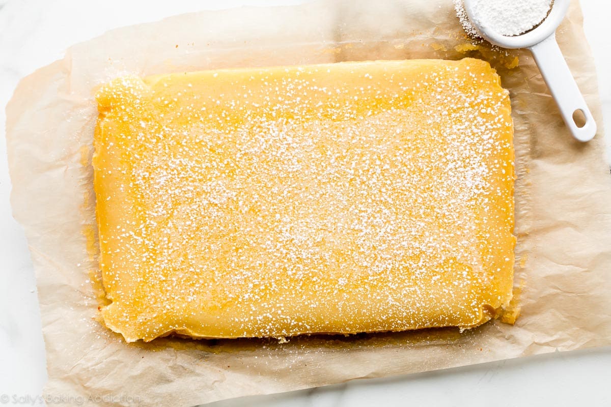 Lemon bars before slicing with powdered sugar on top