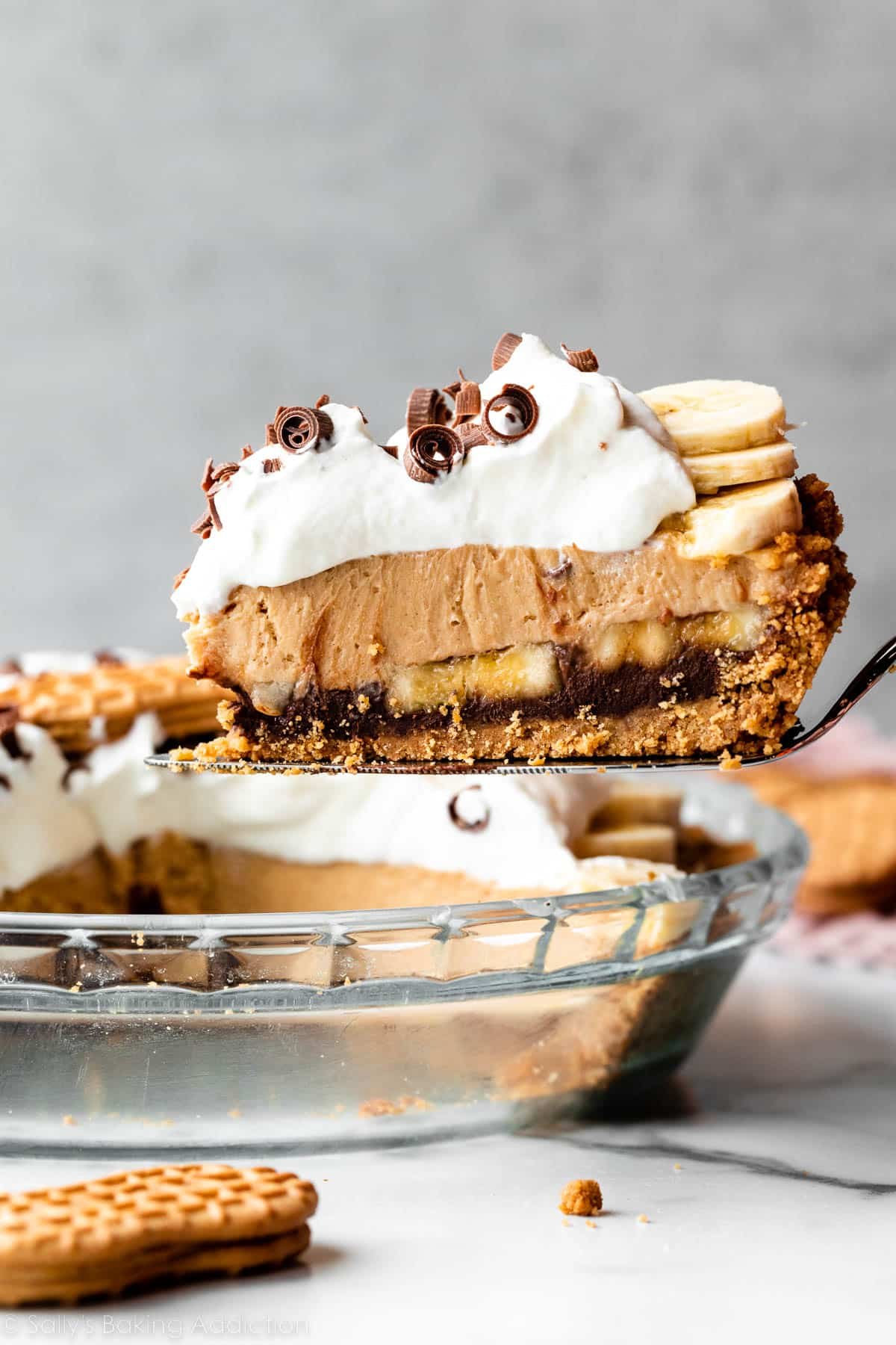 slice of peanut butter banana cream pie being removed from pie dish.