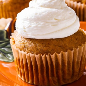 pumpkin cupcakes with marshmallow frosting on an orange plate