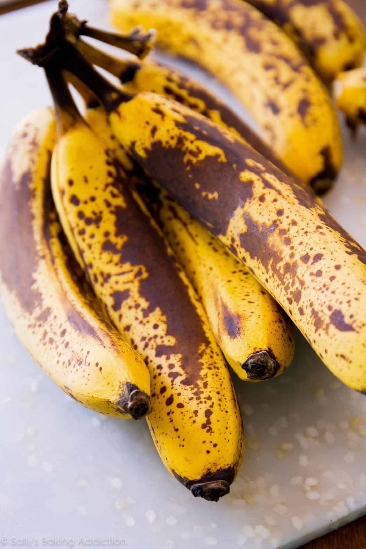 ripe bananas on a white cutting board